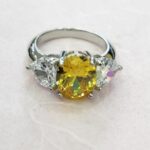 RING WITH OVAL CENTER STONE WITH TWO HEART CZ ON SIDES